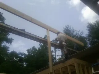 Carpenter setting a ridge beam over a new addition frame — Ice Dam Removal by Roofing Brothers in Nooksack